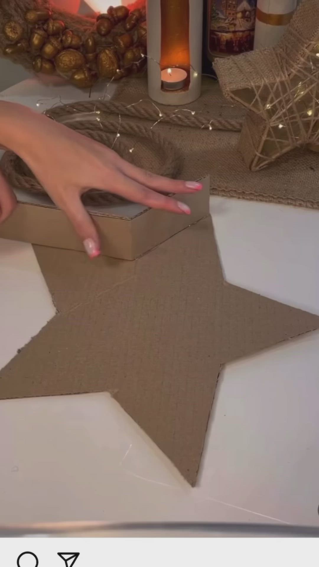 This may contain: a hand reaching for a star shaped cardboard box