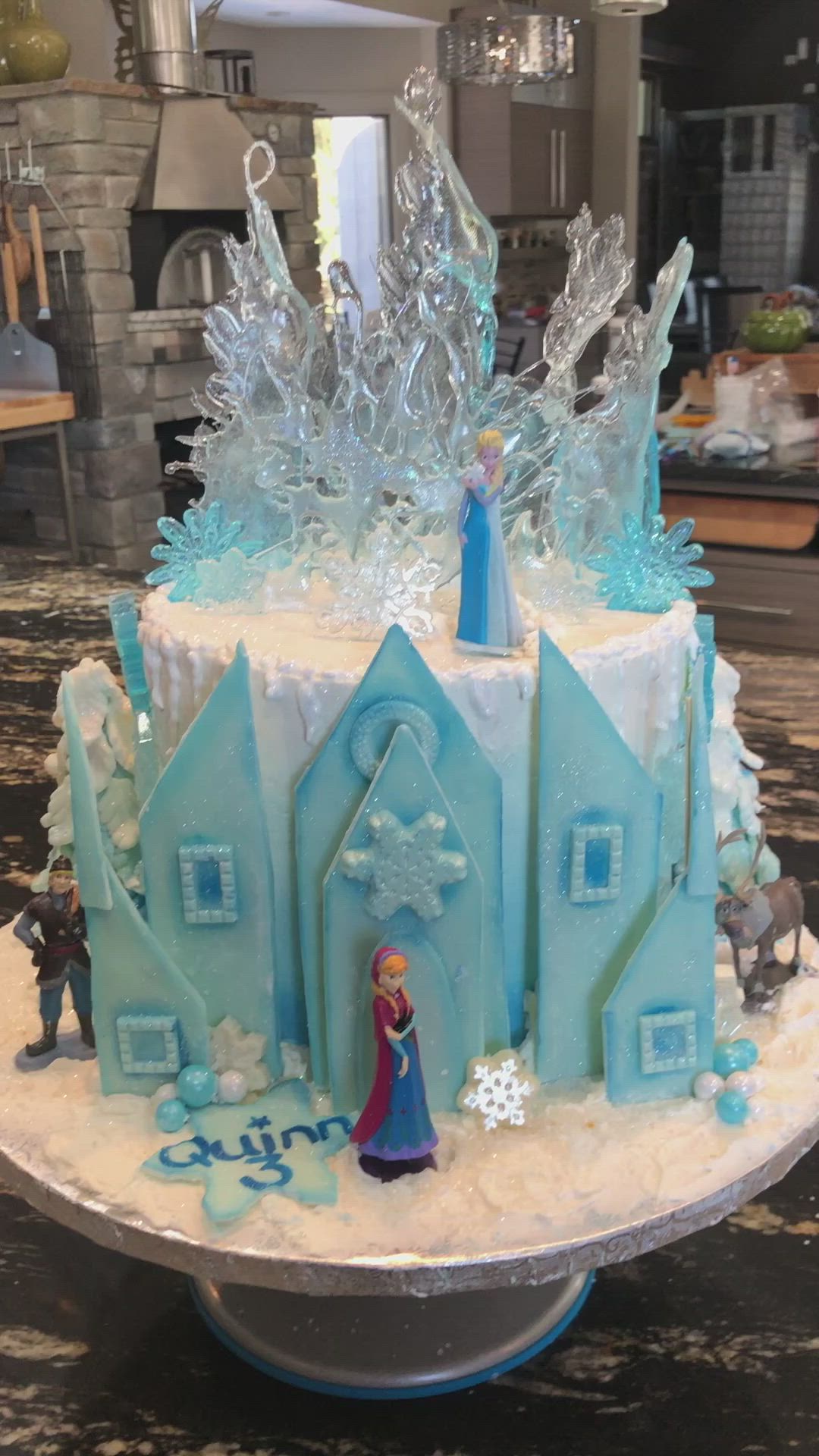 This may contain: there is a cake that looks like it has frozen castle on top and frosted with icing