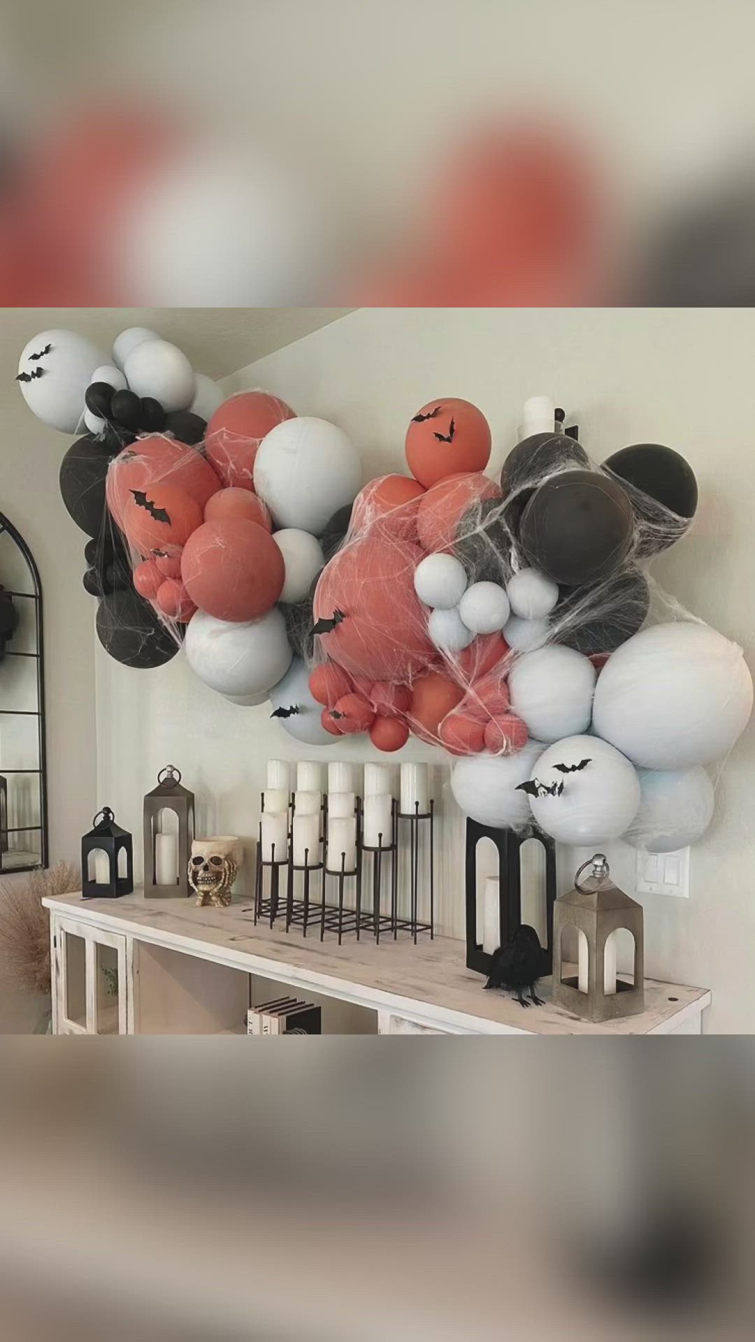 This may contain: an assortment of balloons are hanging on the wall above a table with candles and other decorations