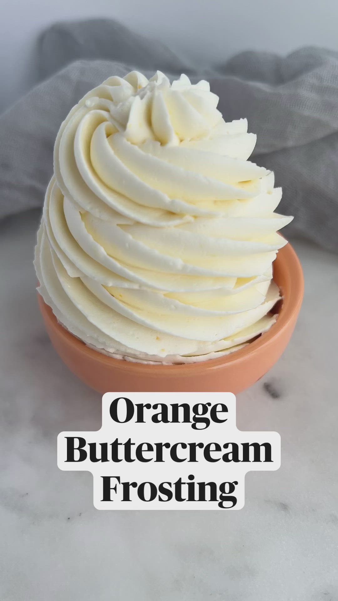 This may contain: an orange buttercream frosting in a bowl with the words orange buttercream frosting