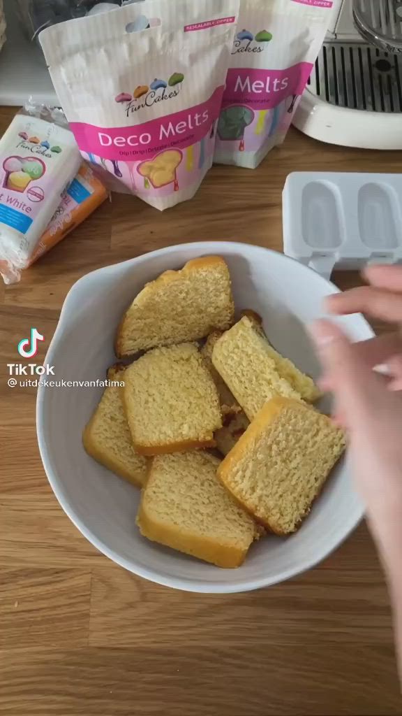 This may contain: a bowl filled with slices of bread on top of a wooden table next to bags of milk