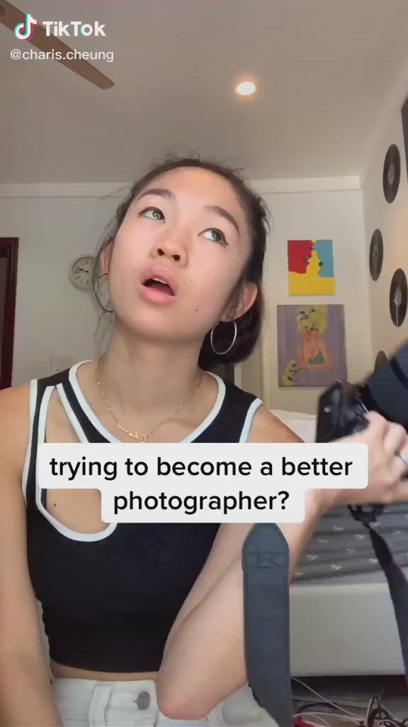 This may contain: a woman holding a camera in her hand and looking up at the sky with text that reads, trying to become a better photographer?