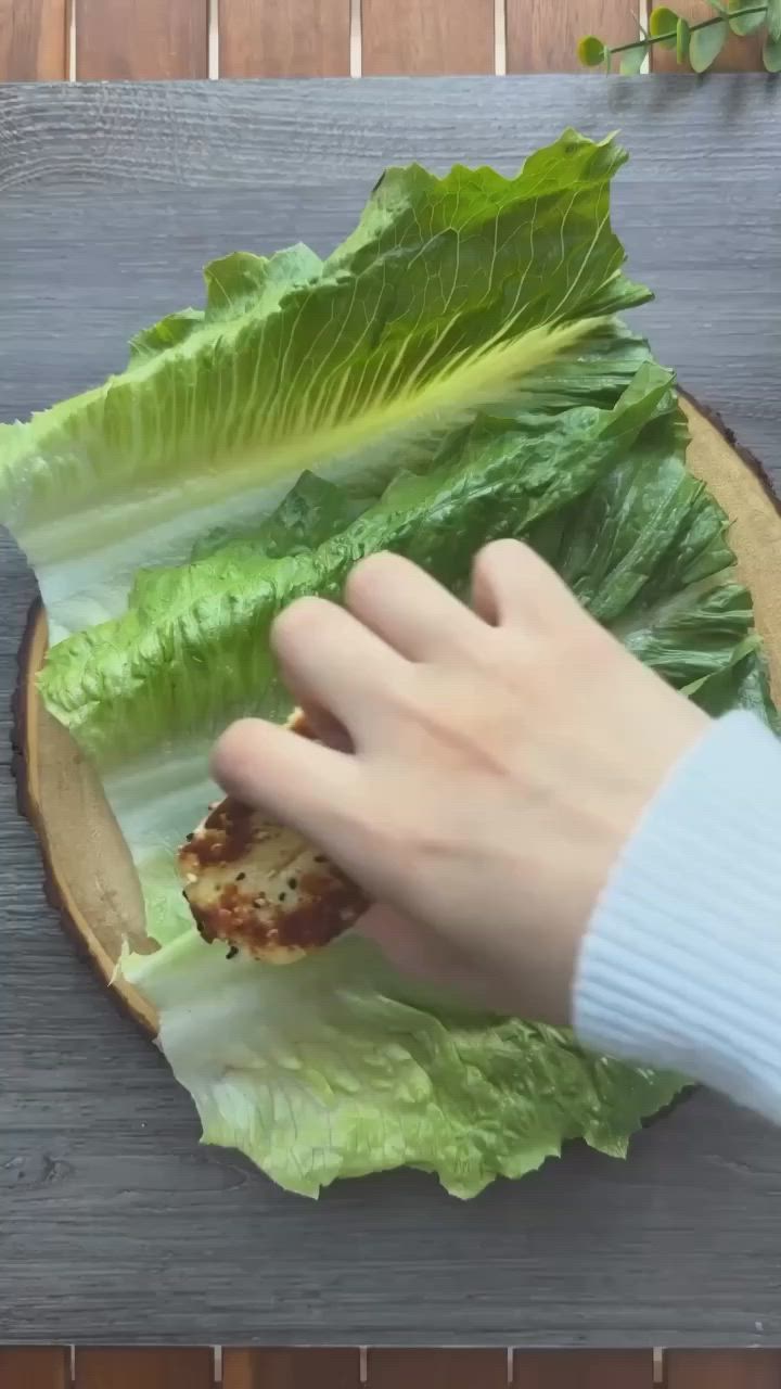 This may contain: a person is cutting lettuce on a wooden board