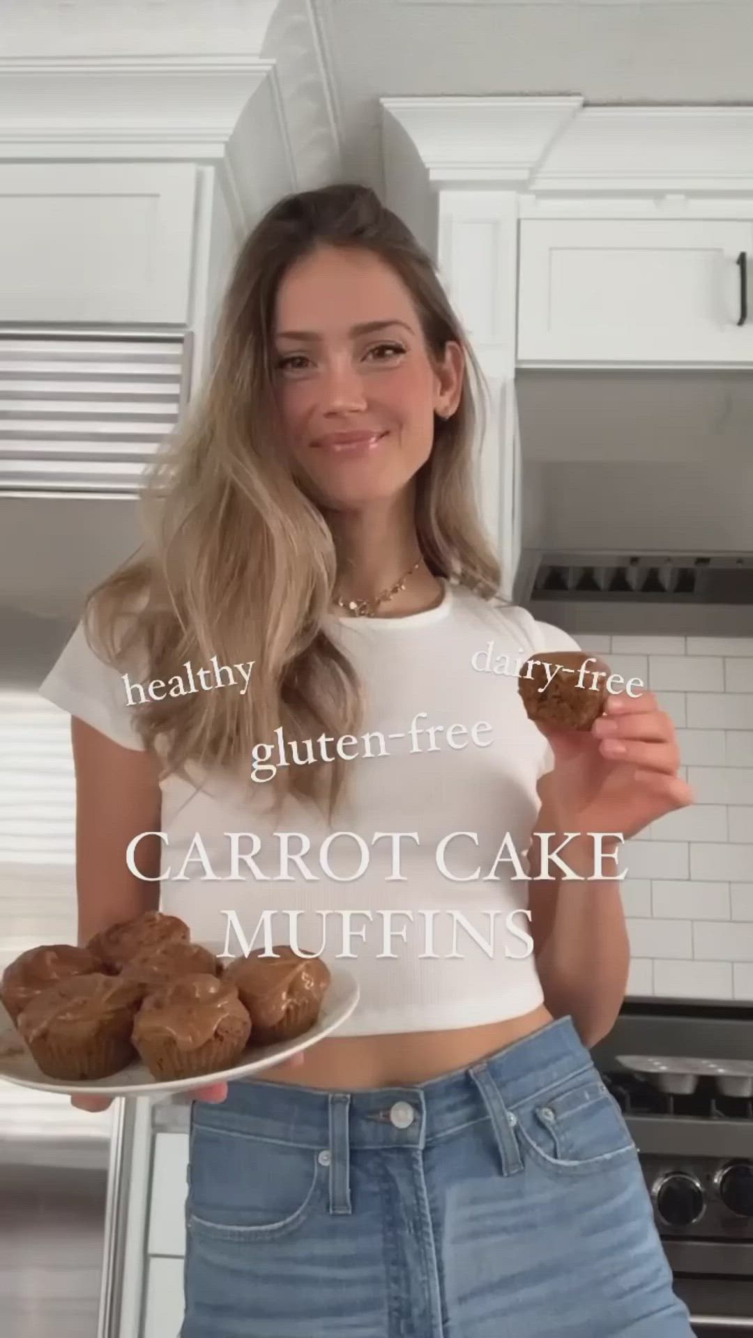 This may contain: a woman holding a plate with some food on it and the caption reads, healthy gluten free carrot cake muffins