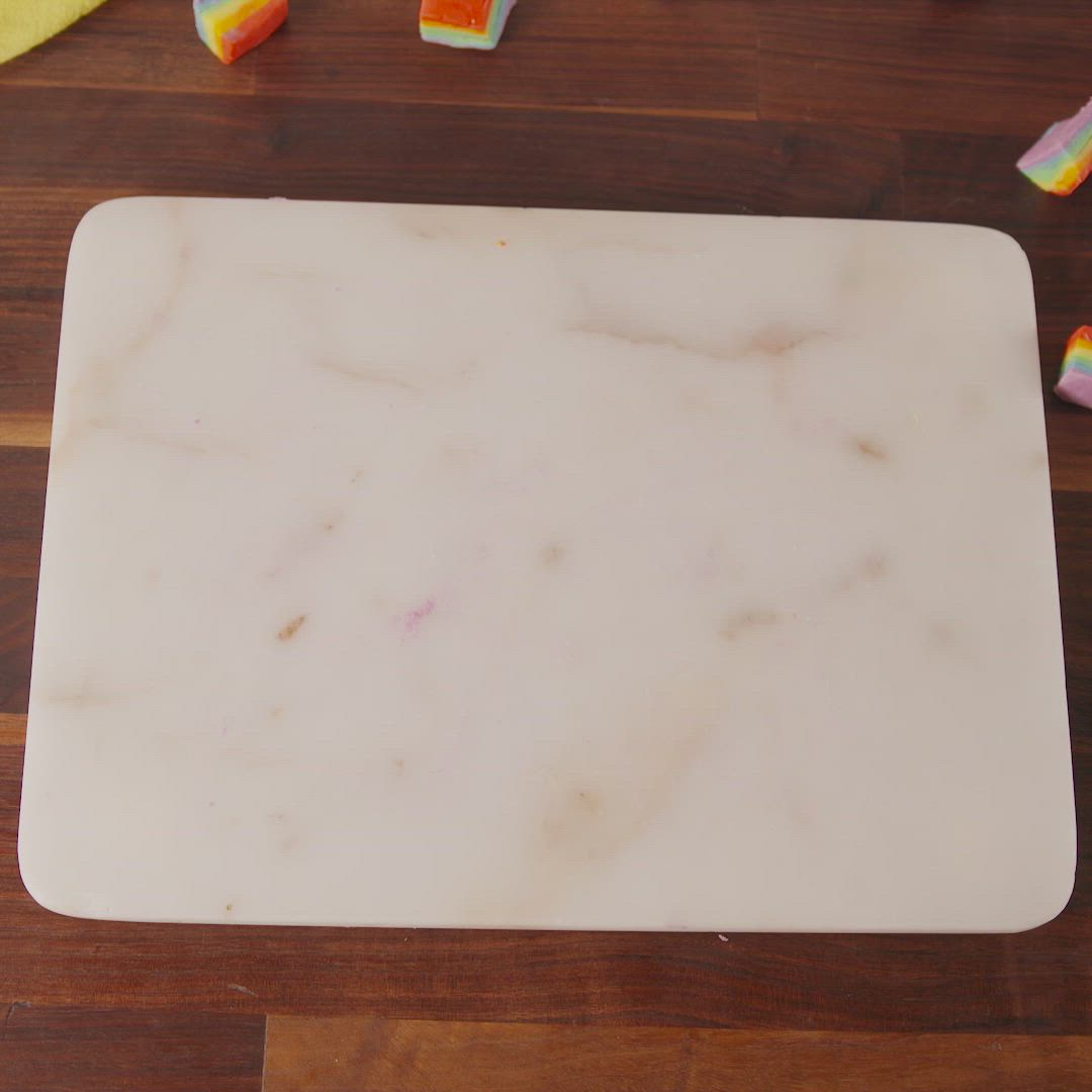 This may contain: a marble cutting board sitting on top of a wooden table next to candy canes