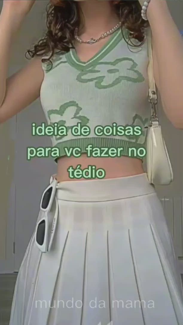 This may contain: a woman in a white skirt holding a cell phone up to her face with the caption'idia de coias para ve fazer no tedio '