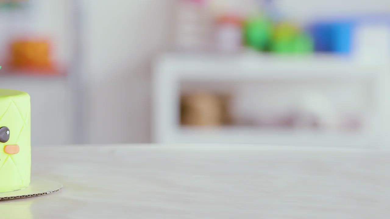 This may contain: a person holding a cake decorated like a pineapple