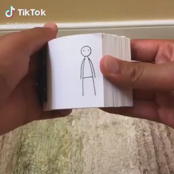 This may contain: a person holding a piece of paper with a drawing on it