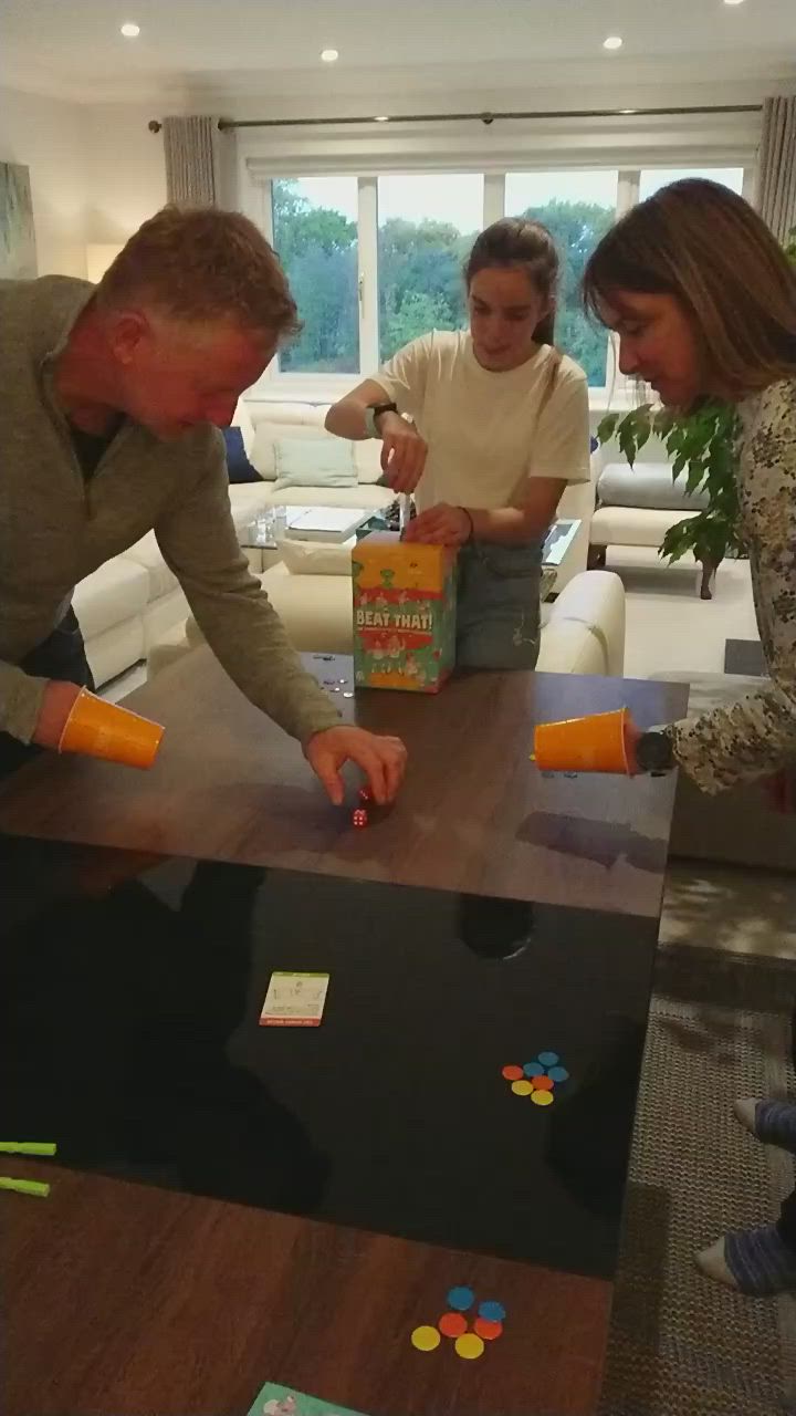 This may contain: three people standing around a table with boxes on it