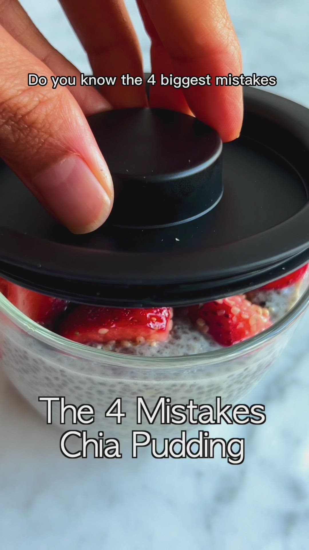 This may contain: a bowl of chia pudding with strawberries and blueberries