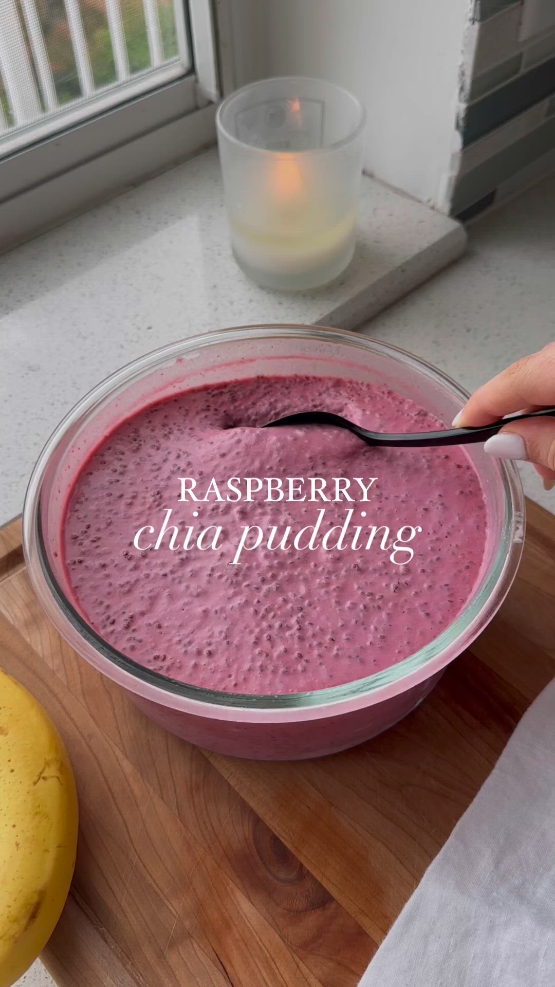 This may contain: a bowl of raspberry chia pudding with a spoon in it