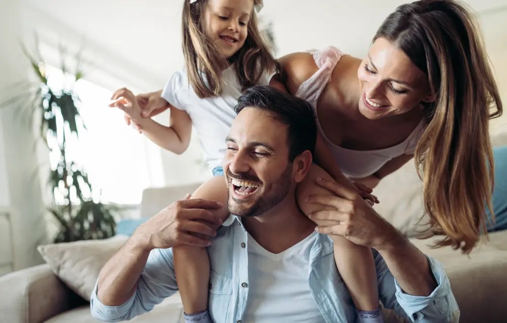 young man and wife playing with their daughter