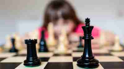 a girl with ADHD keeps her brain sharp during the summer by playing chess