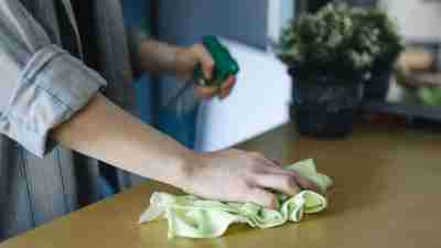 A Person Cleaning a Table with Cleaning Cloth