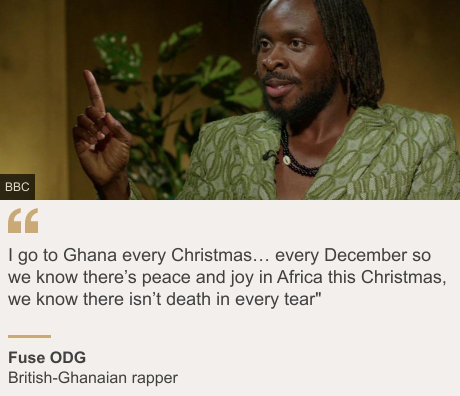 "I go to Ghana every Christmas… every December so we know there’s peace and joy in Africa this Christmas, we know there isn’t death in every tear"", Source: Fuse ODG, Source description: British-Ghanaian rapper, Image: Fuse ODG dressed in a green suit and a beaded necklace has his finger in the air while answering an interviewer's question. 