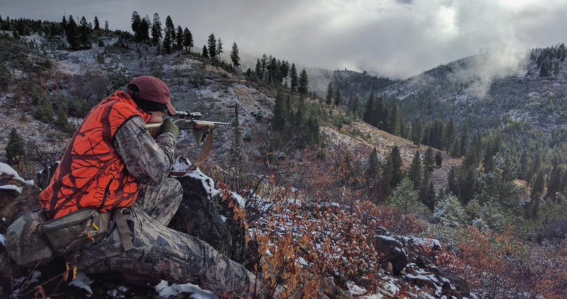 big game hunter dressed in hunter orange taking aim at an animal with his rifle Ben Studer medium shot, November 2016