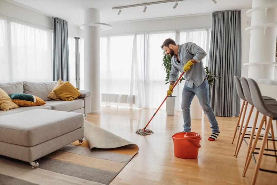 Mann putzt die Wohnung