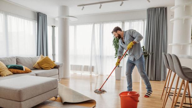 Mann putzt die Wohnung