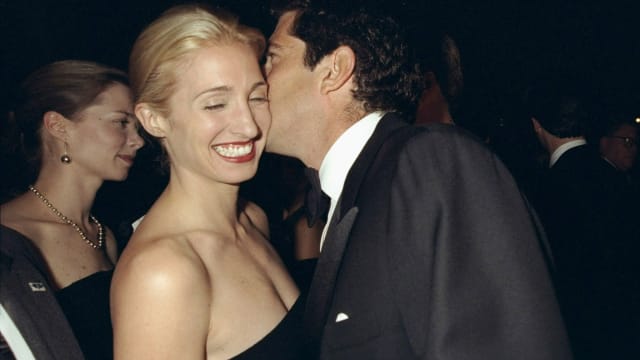 John F. Kennedy Jr. whispers to Carolyn Bessette-Kennedy as they attend a gala dinner in New York on October 5, 1998.