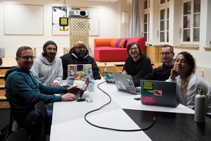 The crew of HWC Nuremberg 01/2025. 6 people with laptops sitting around a table.