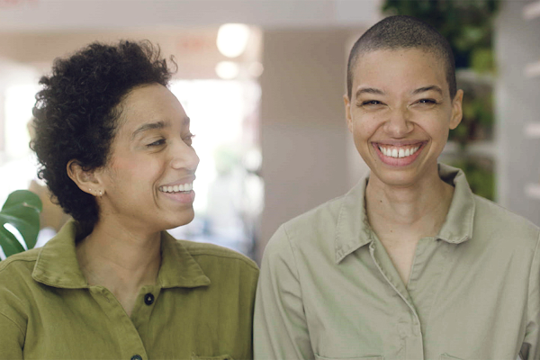 Corianna and Theresa Williams, sisters and owners of Celsious, smile and laugh while sitting next to each other.