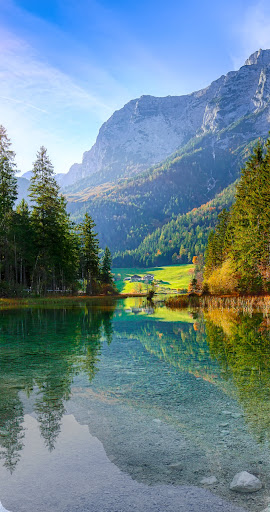 Ein Foto eines Bergsees, das senkrecht geteilt ist. Der linke Teil des Fotos ist gestochen scharf in Ultra HDR mit lebendigen Farben, der rechte Teil in SDR.