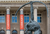 front view of carnegie library with pillers and archer statue in foreground