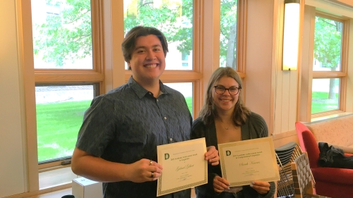 two students with prize certificates