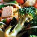 Fry pan of broccoli , carrots, celery, cubed tofu and other vegetables.