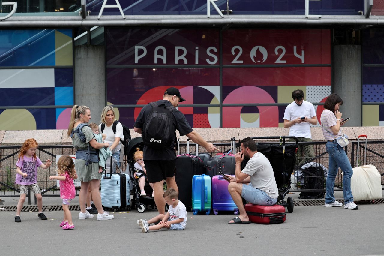 Travellers from Sydney, Australia, wait outside the Gare Montparnasse train station in Paris as they try to search for other trains after their journey was affected by the rail disruptions.