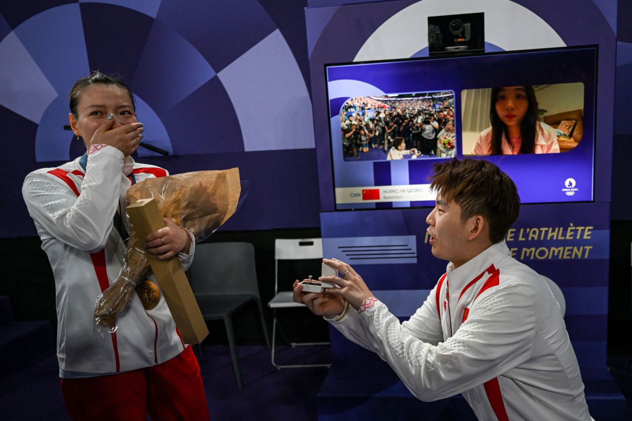 China's Liu Yuchen proposes to his teammate and girlfriend Huang Yaqiong as she left the podium after winning gold at the mixed doubles badminton medal ceremony on Friday. 