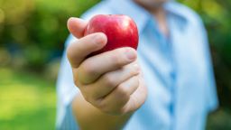 Senior man with apple fruit in green park positive thinking