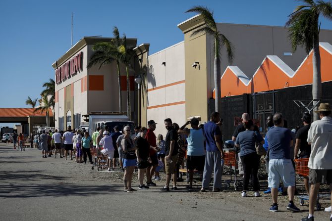 People wait in line to enter a Home Depot store in Cape Coral, Florida, on Friday. Many in Florida were still without power.