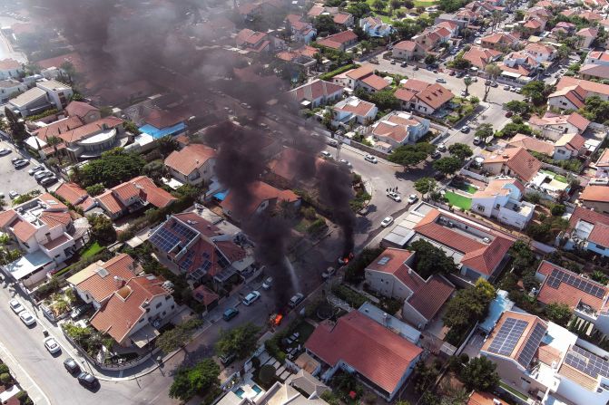 Vehicles in Ashkelon burn as rockets are launched from Gaza on October 7.