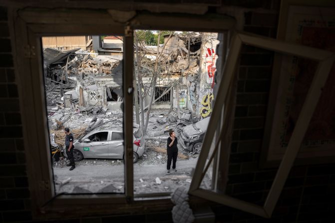 Israelis inspect the rubble of a building in Tel Aviv on October 8, a day after it was hit by a rocket fired from Gaza.