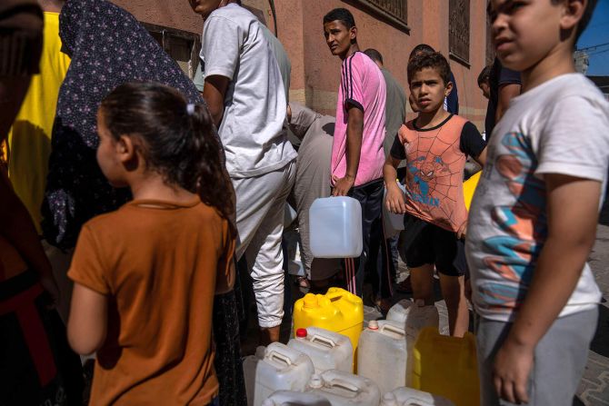 Palestinians collect water from a tap on October 15 after <a href="https://www.cnn.com/2023/10/10/middleeast/gaza-complete-siege-israel-intl/index.html" target="_blank"