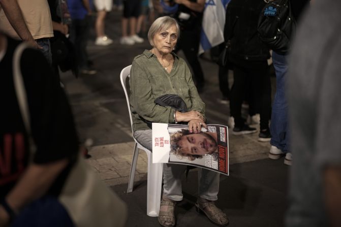 On day 35 of hostages being detained by Hamas, a woman holds the image of a hostage while sitting amongst thousands of people and families of kidnapped people taking part in a protest to demand that Israeli Prime Minister Benjamin Netanyahu secures the release of Israeli hostages, on Saturday, November 11, in Tel Aviv, Israel. 