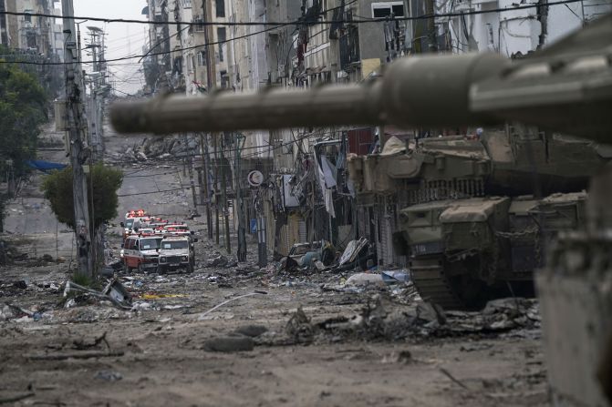 Ambulances are seen on a road near an Israeli forces tank in Gaza on November 22.