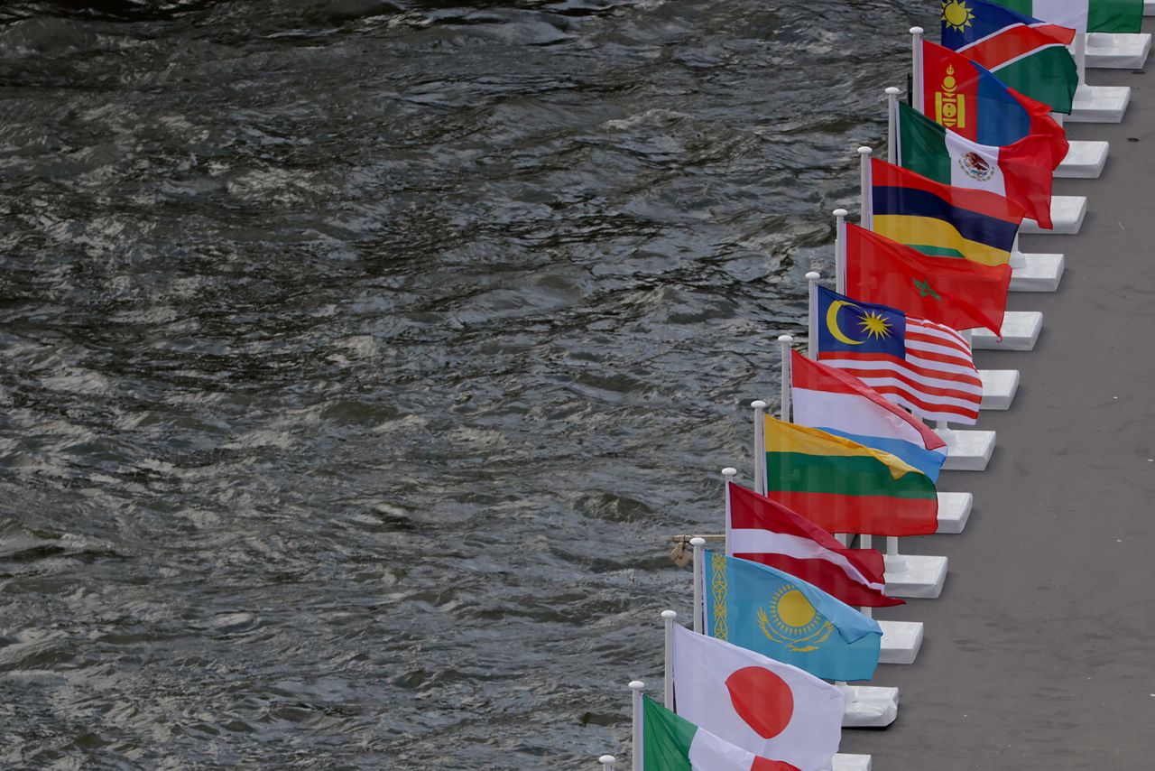 The flags of various countries are seen along the River Seine in Paris on August 1.