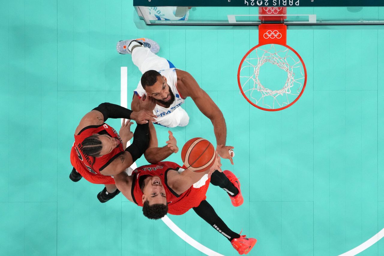 Canada's Dillon Brooks and Dwight Powell go for a rebound against France's Rudy Gobert on Tuesday.