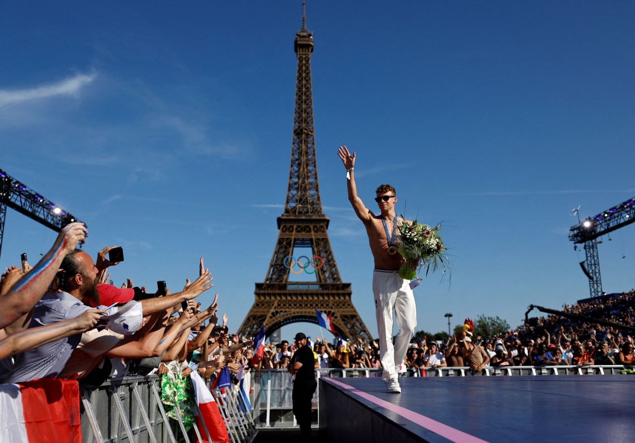 French swimming sensation Léon Marchand greets fans during celebrations in front of the Eiffel Tower on August 6. Marchand won four gold medals and a bronze during these Games.