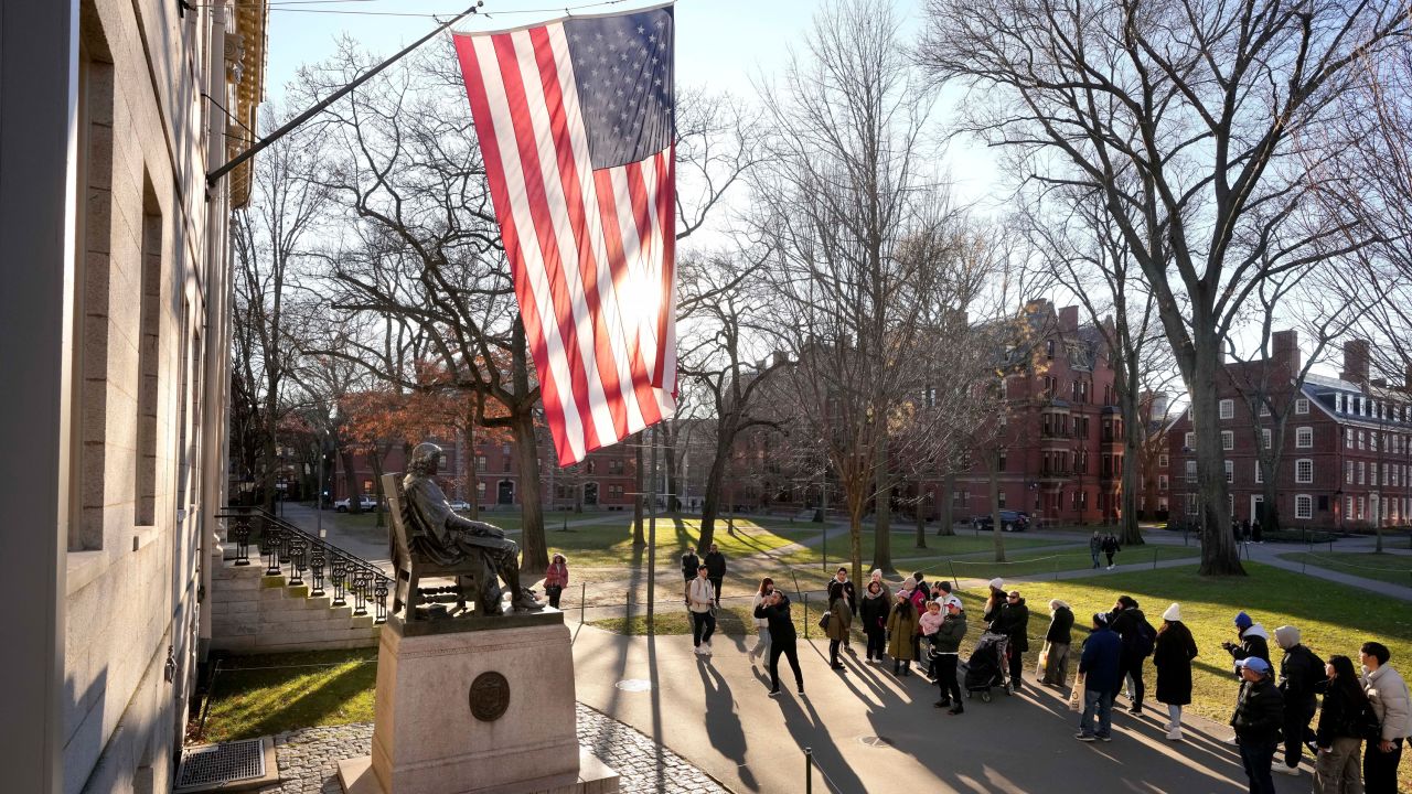 People take photographs near a John Harvard statue, left, Tuesday, Jan. 2, 2024, on the campus of Harvard University, in Cambridge, Mass. Harvard University President Claudine Gay resigned Tuesday amid plagiarism accusations and criticism over testimony at a congressional hearing where she was unable to say unequivocally that calls on campus for the genocide of Jews would violate the school's conduct policy. (AP Photo/Steven Senne)