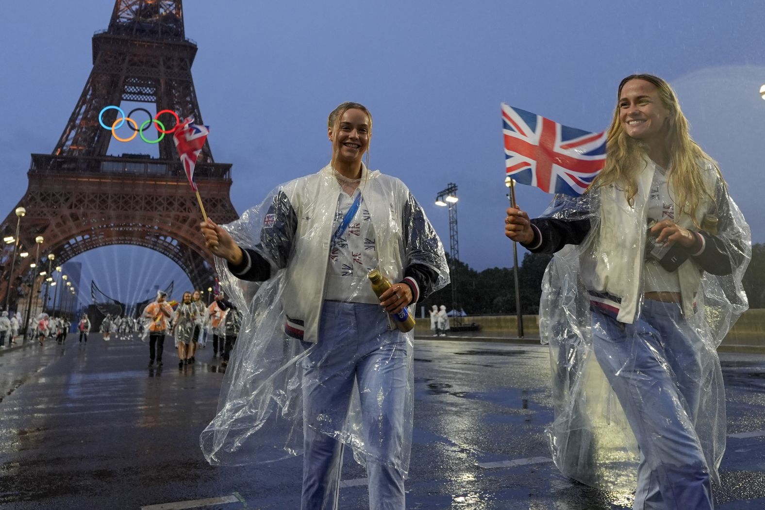 British athletes walk near the Eiffel Tower. A steady rain fell during much of the ceremony.