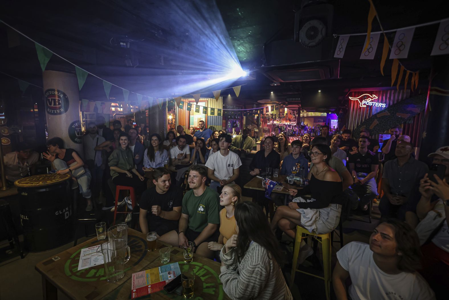 People watch the opening ceremony from a bar in Paris.