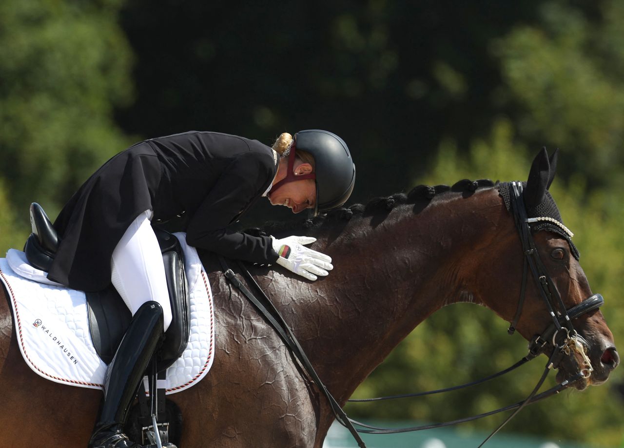 Germany's Jessica Von Bredow-Werndl pets her horse TSF Dalera BB after competing in the equestrian dressage individual grand prix on August 4. 