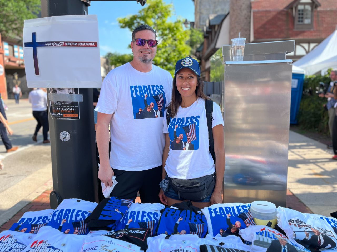 Brad and Andrea Neuser pose with their merchandise being sold outside of the Republican National Convention in Milwaukee. 