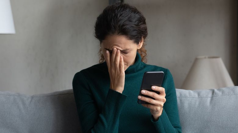 Bad news on screen. Confused frustrated young latin lady cover face with palm turn away from cell seeing important call missed. Desperate millennial woman get message on phone about dismissal from job