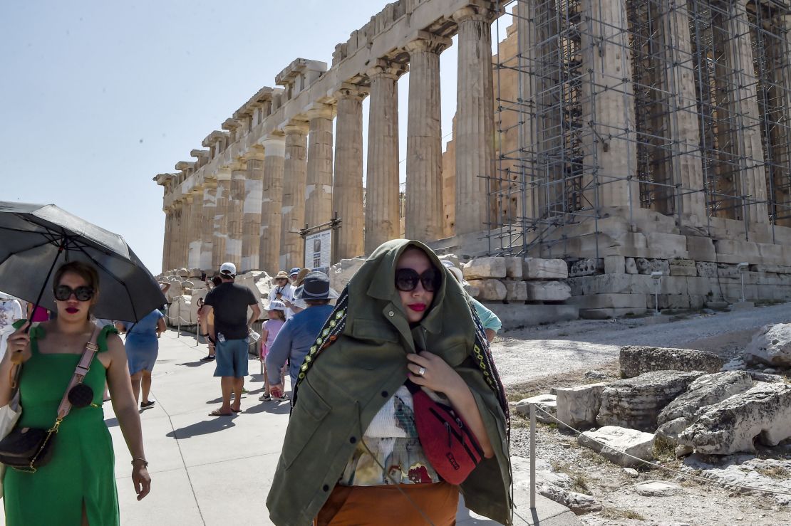 Atop the Acropolis ancient hill, a tourist protects herself from the burning sun during a heatwave on July 20, 2023 in Athens, Greece.