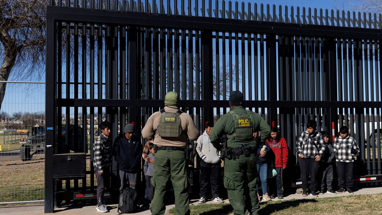 EAGLE PASS, TEXAS - FEBRUARY 4:  U.S. Border Patrol agents guard migrants that crossed into Shelby Park as they wait to be picked up for processing on February 4, 2024 in Eagle Pass, Texas. The Eagle Pass Police Department has barricaded all immediate streets leading to Shelby Park since Friday and only allows media or law enforcement to enter. Texas Gov. Greg Abbott has ordered the Texas National Guard to defy a Supreme Court ruling allowing federal Border Patrol agents complete access into the area which has seen high numbers of illegal crossings. (Photo by Michael Gonzalez/Getty Images)