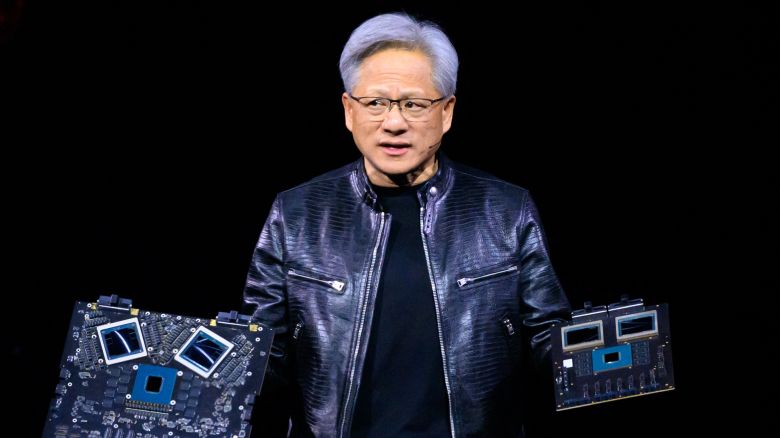 Nvidia's CEO Jensen Huang displays products on-stage.